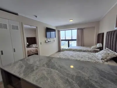 a bedroom with two beds and a large window at Departamento de estreno en San Isidro in Lima