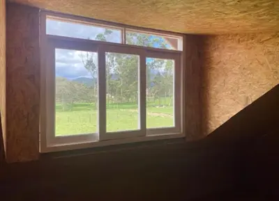 a window in a room with a view of a field at Casa de Campo Miraflores in Oxapampa