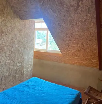 a bedroom with a blue bed and a window at Casa de Campo Miraflores in Oxapampa