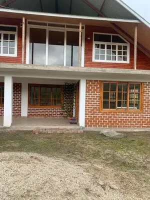 a brick house with a front door and windows at Casa de campo Miraflores in Oxapampa