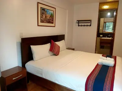 a bedroom with a large white bed with red pillows at El Quetzal MachuPicchu in Machu Picchu