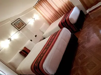 a bedroom with a large bed and a couch at INKA's WALK in Cusco