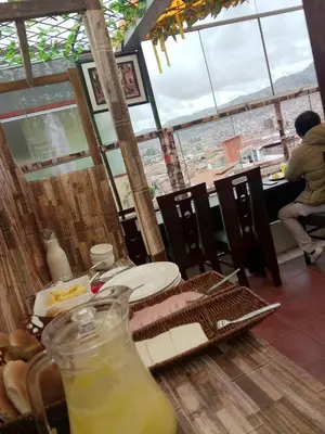 a table with a plate of food and a drink at INKA's WALK in Cusco