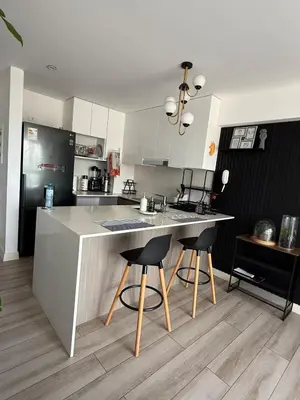 a kitchen with a counter and two bar stools at Rest and comfort in San Isidro in Lima