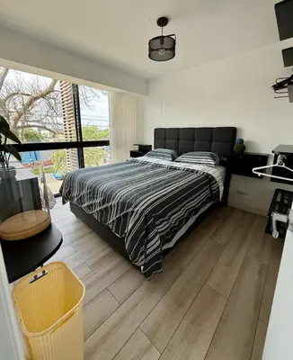 a bedroom with a bed and a large window at Rest and comfort in San Isidro in Lima