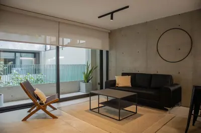 a living room with a black couch and a table at Arrieta by Wynwood House in Lima