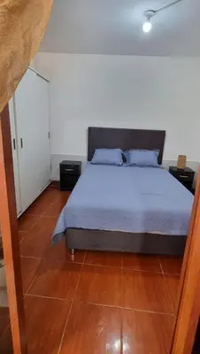 a bedroom with a bed and a wooden floor at Curazao in Punta Hermosa