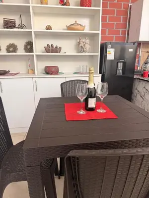 a table with a bottle of wine and two glasses at Curazao in Punta Hermosa
