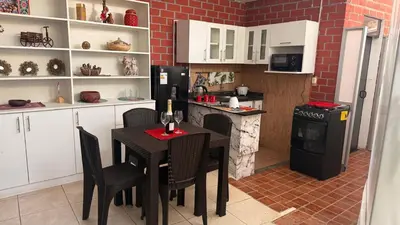 a kitchen with a table with chairs and a refrigerator at Curazao in Punta Hermosa