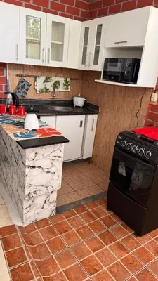 a kitchen with white cabinets and a black stove at Curazao in Punta Hermosa