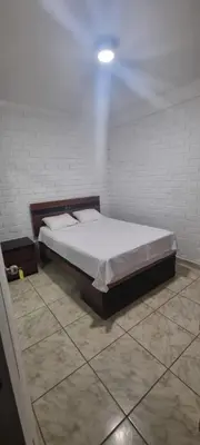 a bedroom with a bed in a white room at Curazao in Punta Hermosa