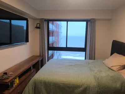 a bedroom with a bed and a large window at Departamento con vista al mar en Lima in Lima