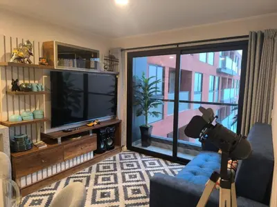 a living room with a television and a camera at Departamento con vista al mar en Lima in Lima