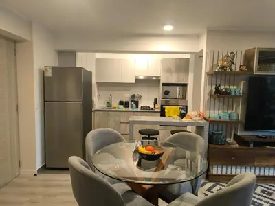 a kitchen with a glass table and chairs and a refrigerator at Departamento con vista al mar en Lima in Lima