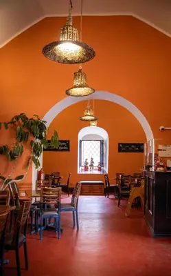a dining room with tables and chairs and a window at ViaVia Ayacucho in Ayacucho