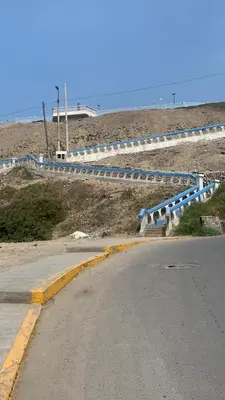 an empty road with blue and white barriers on a beach at Sasso alojamiento in Barranca