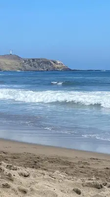 a sandy beach with waves in the ocean at Sasso alojamiento in Barranca