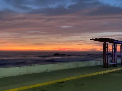 a view of the ocean at sunset from a beach at Sasso alojamiento in Barranca
