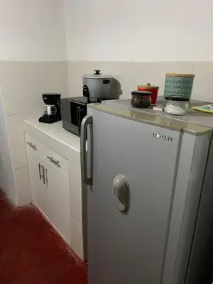 a small kitchen with a refrigerator and a microwave at Sasso alojamiento in Barranca