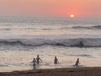 a group of people standing in the water at the beach at Sasso alojamiento in Barranca