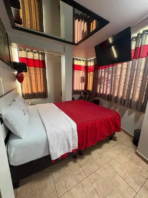 a bedroom with a large bed with a red blanket at Hospedaje Winikunka in Lima