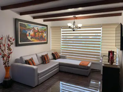 a living room with a couch and a large window at Apartamento Tumi Wasi in Lima