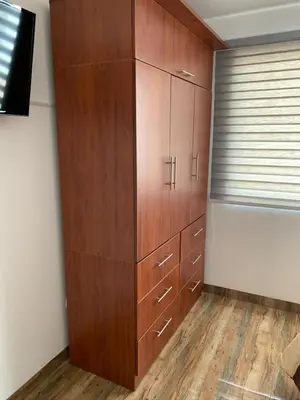 a large wooden cabinet in the corner of a room at Apartamento Tumi Wasi in Lima