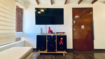 a living room with a flat screen tv on a wall at Apartamento Tumi Wasi in Lima