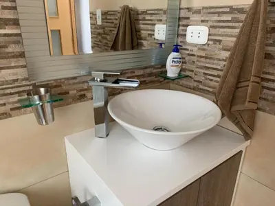 a bathroom with a white sink and a mirror at Apartamento Tumi Wasi in Lima