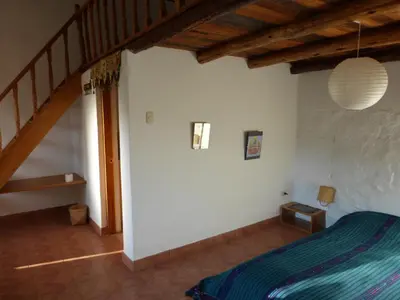 a bedroom with a bed and a wooden staircase at Andean Spirit Lodge in Mollepata
