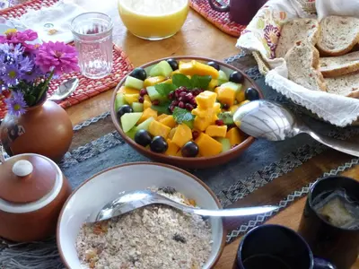 a table with a bowl of fruit and a bowl of bread at Andean Spirit Lodge in Mollepata