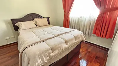a large bed in a bedroom with a window at Apartamento de 3 dormitorios frente a plaza San Miguel con Piscina in Lima