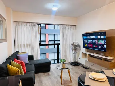 a living room with a couch and a flat screen tv at MONTERRICO POLO APARTS #21 - Dpto 2 Dorm Frente Embajada de USA in Lima