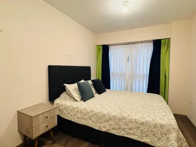 a bedroom with a bed and a window with green curtains at MONTERRICO POLO APARTS #21 - Dpto 2 Dorm Frente Embajada de USA in Lima