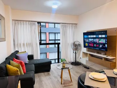 a living room with a couch and a flat screen tv at MONTERRICO POLO APARTS #21 - Dpto 2 Dorm Frente Embajada de USA in Lima
