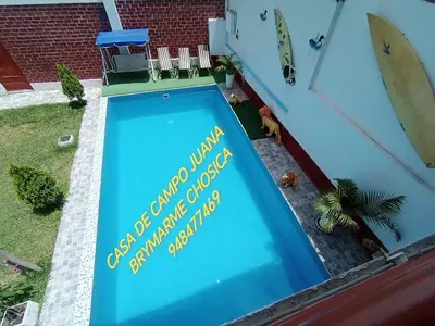 a swimming pool with a sign on the side of a house at Casa de campo juana brymarme in Chosica
