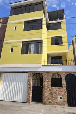 a yellow building with two garage doors at Galicia Lodgement in Lima