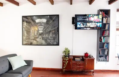 a living room with a couch and a tv on a wall at The film House in Lima