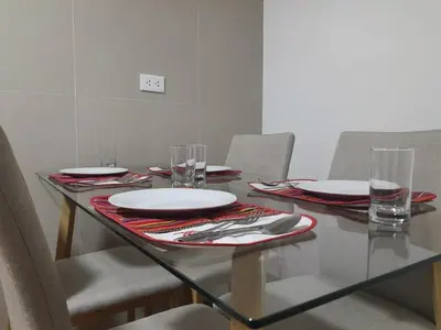 a dining table with plates and glasses on it at Cozy Apartment for Tourist in Lima
