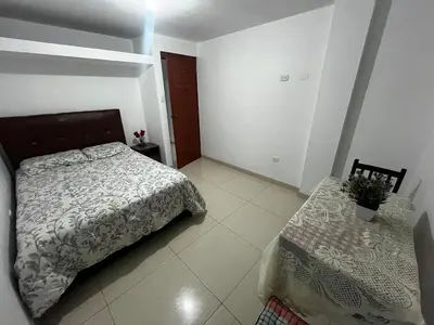 a bedroom with a bed and a table at Departamento Centro Histórico in Ayacucho