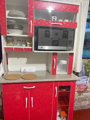 a kitchen with red cabinets and a microwave at Casa Secretos in Cusco