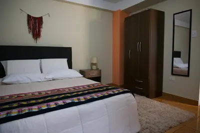a bedroom with a large bed and a dresser at Casa Secretos in Cusco