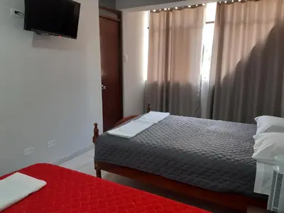 a bedroom with a bed and a window with a television at Casa El Valle de Lunahuaná in Lunahuaná