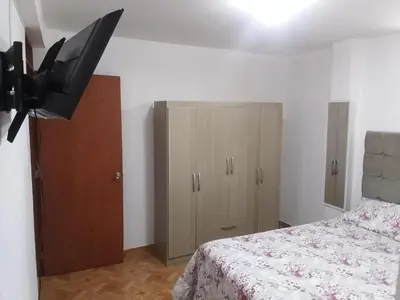 a bedroom with a bed and a flat screen tv at Departamento en Centro de Lima - Santa Beatriz in Lima
