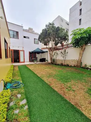 a yard with green grass and a building at Casa Villa Descanso in Lima