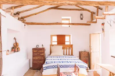 a bedroom with a bed and a wooden ceiling at Casa Takiy in Maras