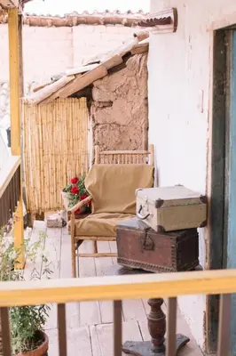 an old chair sitting on a porch with suitcases at Casa Takiy in Maras
