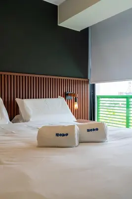 a bed with two towels on top of it at Plaza 27 by Geko in Lima