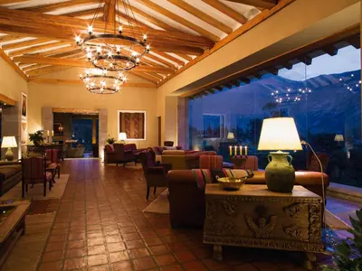 a lobby with couches and a lamp on a table at Inkaterra Hacienda Urubamba in Urubamba