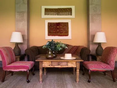 a living room with a couch and two chairs and a table at Inkaterra Hacienda Urubamba in Urubamba